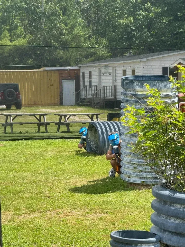 Two masked players behind black corrugated tube bunkers on Hyperball